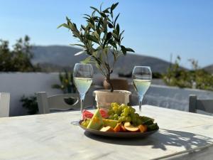 une assiette de fruits et deux verres de vin sur une table dans l'établissement Nature & Sea Lipsi, à Lipsi