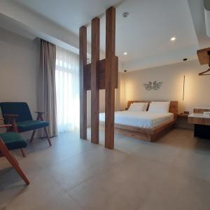a bedroom with a large bed and a blue chair at Nilus Boutique Hotel in Urla