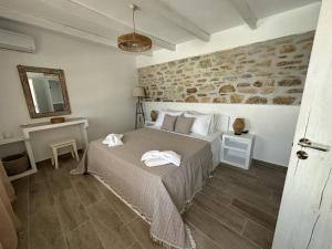 um quarto com uma cama e uma parede de pedra em Nature & Sea Lipsi em Lipsoi
