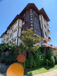 a building with a sign on the side of it at Garden studio Kent in Sveti Vlas