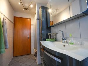 a bathroom with a sink and a wooden door at Ferienwohnungen Maierhof Oberried in Oberried