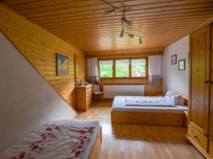 1 dormitorio con 2 camas y techo de madera en Ferienwohnungen Maierhof Oberried, en Oberried