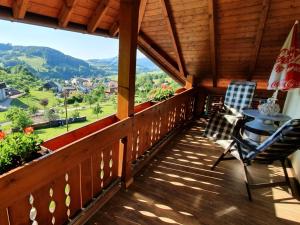 - Balcón de cabaña con mesa y sillas en Ferienwohnungen Maierhof Oberried, en Oberried