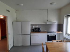 a kitchen with a white refrigerator and a table at Mäshult Kurs & Lägergård in Skällinge +22 photos