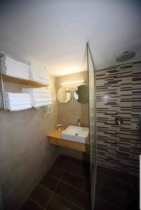 une salle de bain avec un lavabo et une douche en verre dans l'établissement XdreamPort, à Chersónissos