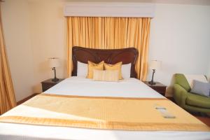 1 dormitorio con 1 cama y 1 silla verde en Hotel Los Portales, en Chinandega