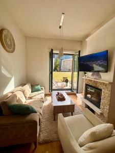 a living room with two couches and a fireplace at Srna Apartment - Bjelašnica in Bjelašnica +13 photos