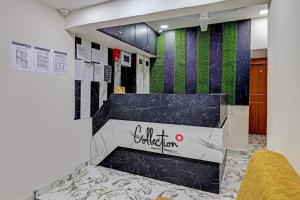 a lobby with a black and green wall at Collection O Hotel Previliege View in Ahmedabad