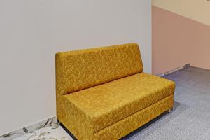 einem gelben Stuhl in der Ecke eines Zimmers in der Unterkunft Collection O Hotel Previliege View in Ahmedabad