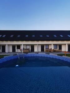 un edificio con piscina en frente de un edificio en Sunrise Marina Domki Mielno- Ferienhaus, en Mielenko