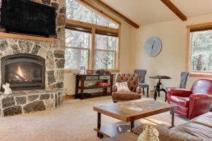a living room with a stone fireplace and a tv at Tahoma Deluxe Brand New Home in Tahoma