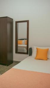 1 cama con almohada naranja y espejo en Kothmale Homestay, en Mawatura