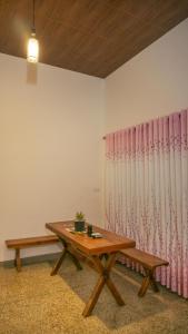 Habitación con mesa y cortina rosa en Kothmale Homestay, en Mawatura