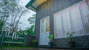 a brick house with windows and a fence at Kothmale Homestay in Mawatura