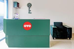 a green desk with a red oo sign next to a chair at OYO Flagship Night Quine Guest House in Pānchuria