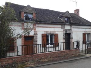 an old white house with a black fence at Maison chaleureuse avec cheminée des coudrais 
