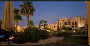 vistas a un edificio con palmeras y sombrilla en Hermoso piso para 4 Pax Corvera Golf Country Club en Corvera
