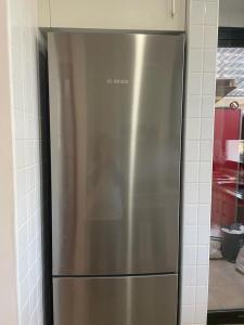 a stainless steel refrigerator in the corner of a kitchen at Hermoso piso para 4 Pax Corvera Golf Country Club in Corvera