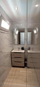 a bathroom with two sinks and two mirrors at Buenavista Estudio Torremolinos in Torremolinos