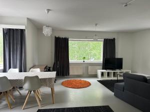 Una sala de estar con una mesa y sillas y un televisor. en Hostel400Kokkola Neliö Saunalla, en Kokkola