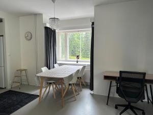 Un comedor con mesa y sillas y una ventana. en Hostel400Kokkola Neliö Saunalla, en Kokkola