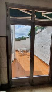 een open deur naar een patio met een tafel en stoelen bij La Llave 