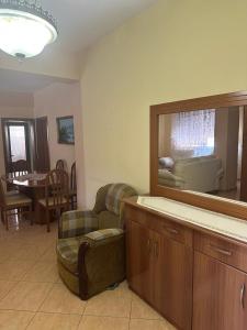 ein Wohnzimmer mit einem Spiegel, einem Stuhl und einem Sofa in der Unterkunft Apartment City Center Best Price in Fier