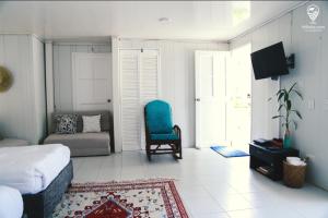 a bedroom with a bed and a chair and a couch at CABAÑA EL ARBOL CARTAGENA in Cartagena de Indias