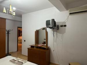 a room with a mirror and a tv on a wall at Apartment City Center Best Price in Fier