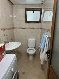 a bathroom with a white toilet and a sink at Apartment City Center Best Price in Fier