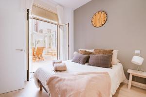 Un dormitorio con una cama grande con un reloj en la pared. en Casa San Miguel Terrace - Centro Zaragoza, en Zaragoza