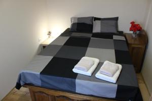 Una cama blanca y negra con dos toallas. en Apartman AS en Belgrado