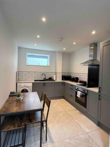 a kitchen with a table and a stove and a sink at Entire property in Downham Market, Serviced Accomodation in Downham Market