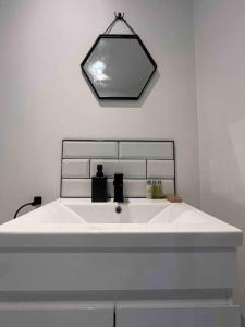 a bathroom with a white sink and a mirror at Entire property in Downham Market, Serviced Accomodation in Downham Market