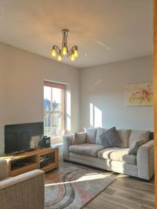 a living room with a couch and a flat screen tv at The Old Warehouse. Warehouse Conversion in quiet central location 2 bed. in Great Yarmouth