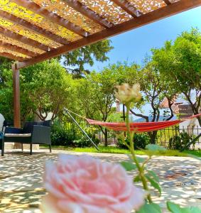 a hammock on a patio with a table and a flower at Villa Naya by the Beach in Anavyssos