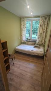 um pequeno quarto com uma cama e uma janela em Zielono mi....... em Jelenia Góra
