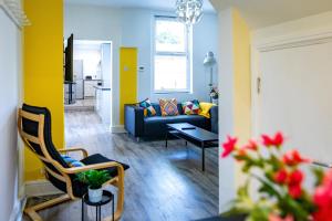 uma sala de estar com um sofá azul e paredes amarelas em 6bd Home-Contractors A+ Location em Sheffield
