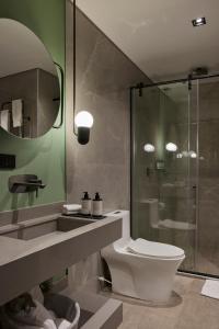 a bathroom with a toilet and a glass shower at Hotel Selis in Medellín