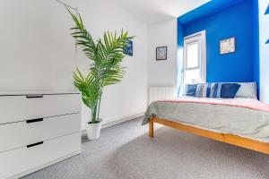 um quarto azul e branco com uma cama e uma planta em 6bd Home-Contractors A+ Location em Sheffield