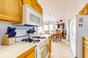 a kitchen with a stove and a white refrigerator at La Cana Street Leisure - Main Home in Coupeville