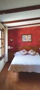 チュリリャにあるAlojamiento La Presaの赤い壁のベッドルーム1室(白いベッド1台付)
