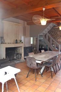 ein Esszimmer mit einem Tisch, Stühlen und einem Kamin in der Unterkunft Domaine de KIBA - Maison de Maitre in Barzan