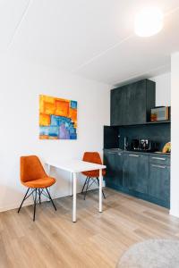 eine Küche mit einem weißen Tisch und 2 Stühlen in der Unterkunft Green-Building Appartement in Bielefeld