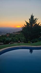 a swimming pool with a sunset in the background at Casa El Mirador 