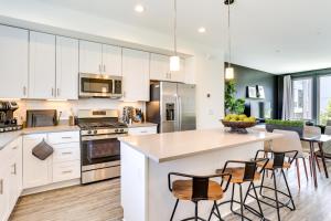 a kitchen with white cabinets and a island with bar stools at WFH-Friendly Philadelphia Rental Near Center City! in Philadelphia