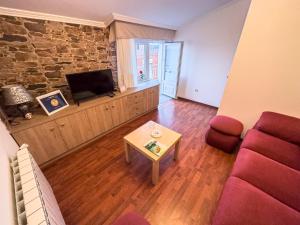 a living room with a couch and a tv and a table at Casa Gonzalo in Arou