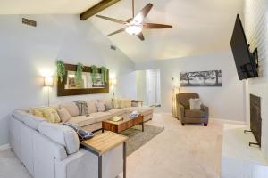 a living room with a couch and a ceiling fan at Chic Lewisville Getaway with Private Pool and Hot Tub! in Lewisville