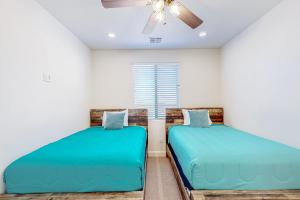 2 bedden in een slaapkamer met een plafondventilator bij Arena Roja House in Washington +36 foto's
