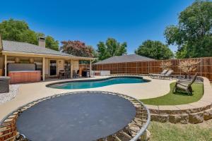a swimming pool in the backyard of a house at Chic Lewisville Getaway with Private Pool and Hot Tub! in Lewisville